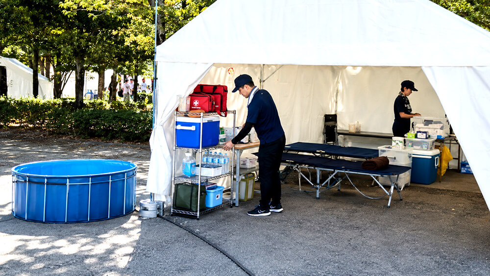 屋外イベントの救護テントで熱中症応急セットを準備する様子