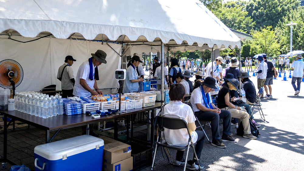 屋外イベントで熱中症対策用の本部テントを設置する様子