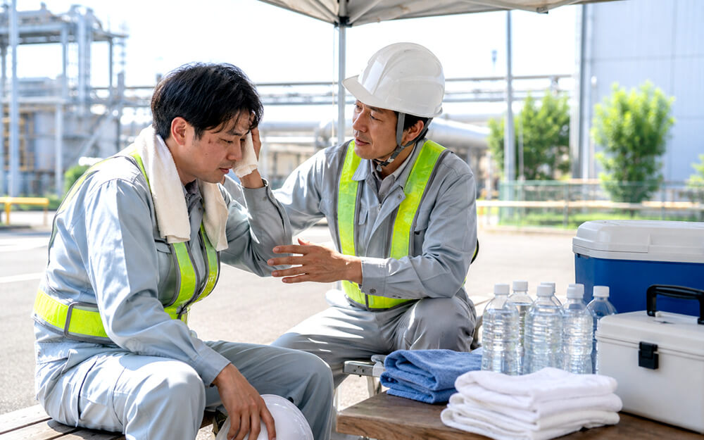 熱中症が疑われる作業者に声をかけて休憩を促す安全担当者