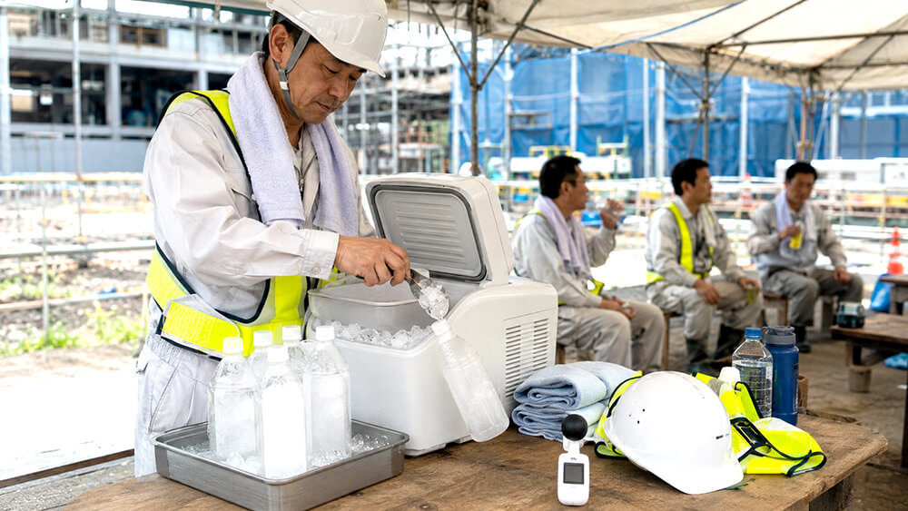 建設現場の休憩所でアイススラリーを準備する安全担当者