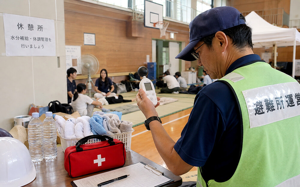 避難所内で暑さ指数を確認する運営担当者