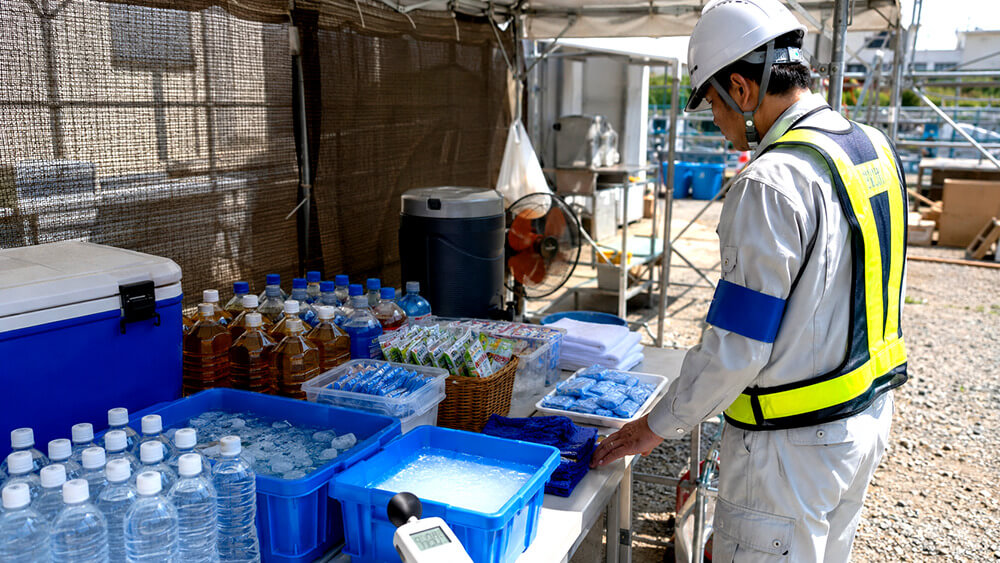 現場で水分補給ステーションとWBGT計を確認する安全担当者